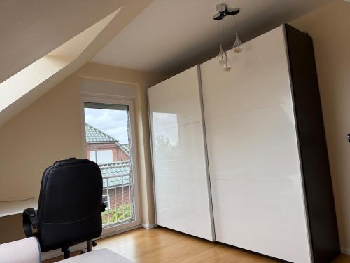 a room with a chair and a large window at Doppelhaushälfte 125m2 3 Zimmer 2 Badezimmer Küche 5 Schlafplätze nähe Hamburg in Stelle