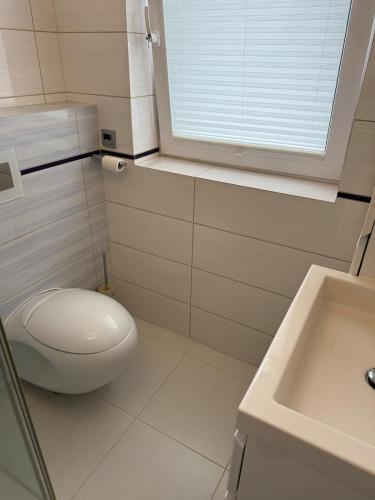 a white bathroom with a toilet and a sink at Doppelhaushälfte 125m2 3 Zimmer 2 Badezimmer Küche 5 Schlafplätze nähe Hamburg in Stelle