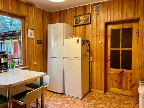 a kitchen with a white refrigerator and a table at Vesiroos Villa in Alajõe