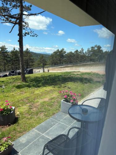 a patio with a table and a view of a field at Divčibarski pogledi in Divčibare