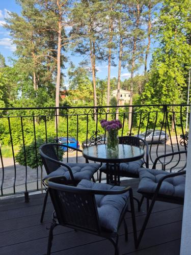 a patio with a table with chairs and flowers on it at Apartament z widokiem na Dom Oficera in Borne Sulinowo
