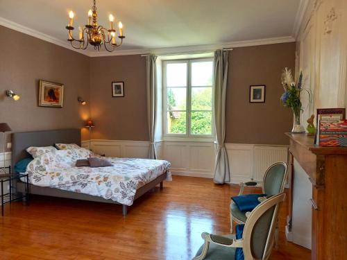 a bedroom with a bed and a window and chairs at Au pays de Jacquou : Chambre d’hôtes et table d’hôtes in Fossemagne