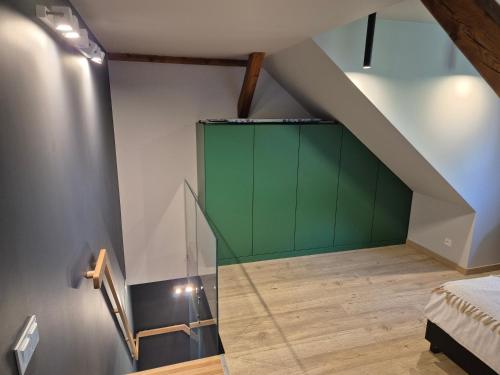 a room with a green door in a attic at Apartament z widokiem na Dom Oficera in Borne Sulinowo