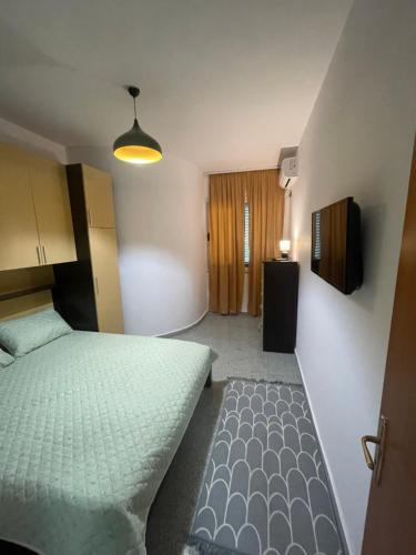 una piccola camera da letto con un letto e una televisione di Waves & Views Apartment a Durrës