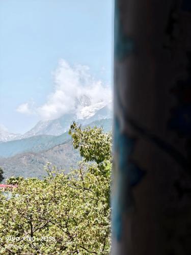 a view of a mountain from a window at SAAR Palampur Villa 5 BHK With Dhauladhaar Mountains View in Pālampur
