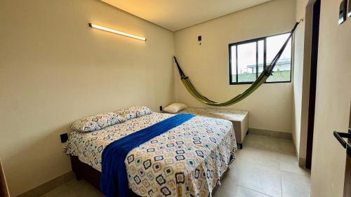 a bedroom with a bed and a hammock in it at Suítes Refúgio Serrano in Bananeiras