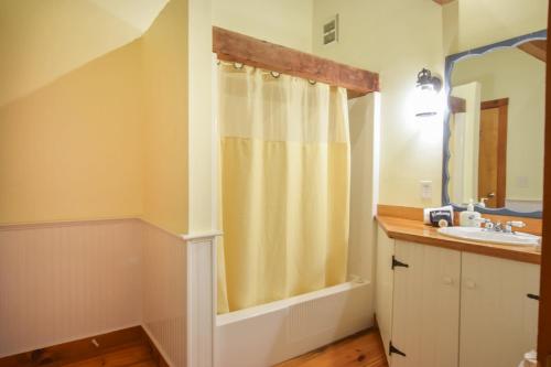 a bathroom with a shower and a sink at Steps to Freshwater Beach Kayaks Sauna in Brewster