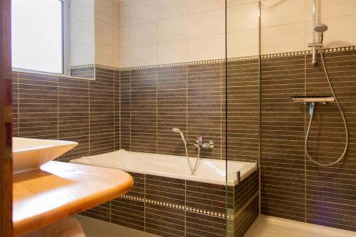 a bathroom with a shower and a tub and a sink at Gite Ungersberg in Itterswiller