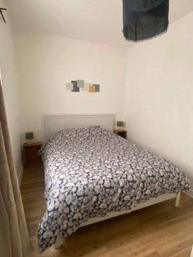 une chambre avec un lit dans une pièce blanche dans l'établissement Appartement cosy dans la bastide, à Sainte-Foy-la-Grande