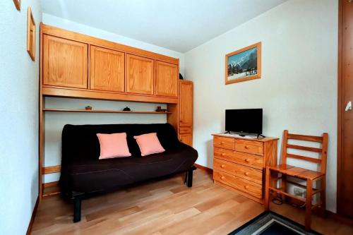 une chambre avec un canapé noir avec deux oreillers roses dans l'établissement Résidence Le Prarion 2 C - Prarion 2 28 MAE-6429, aux Houches