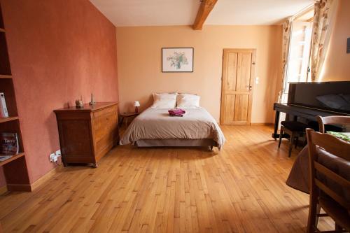 a bedroom with a bed and a piano at Au coeur de Montastruc-la-Conseillère - Chambres d'hôtes in Montastruc-la-Conseillère