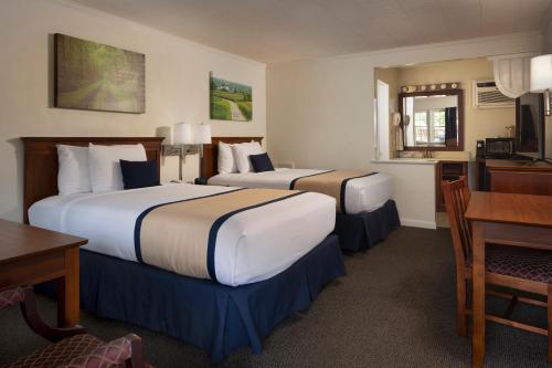 a hotel room with two beds and a desk at Travelers Rest Motel in Intercourse