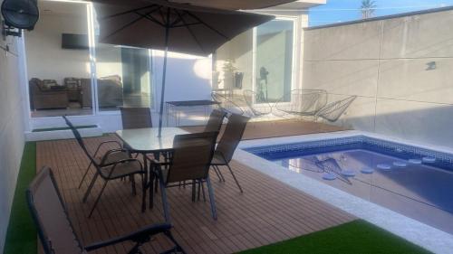 Un patio con mesa y sillas junto a una piscina. en House in Teques Rooftop with view and pool for 15, en Tequesquitengo