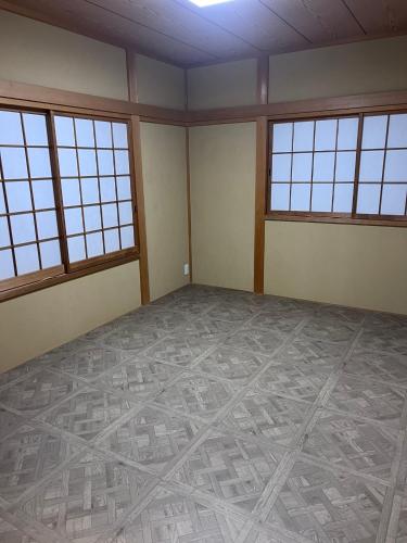 an empty room with windows and a tiled floor at コテージ33 in Nasu