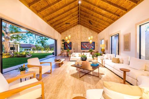 a living room with white furniture and a large window at Casa Ceiba in La Romana
