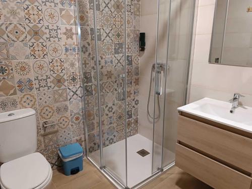 a bathroom with a shower and a toilet and a sink at Apartamentos de Turismo Rural La Rocha in Fortanete