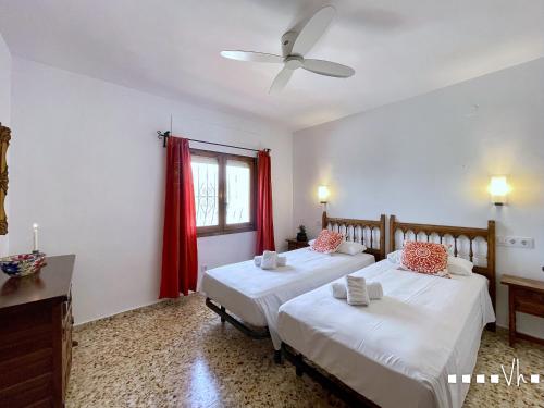 two beds in a room with red curtains at VH CostaBlanca - RULLE in Benissa