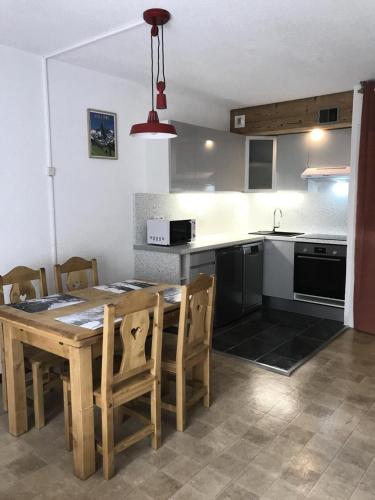 une cuisine et une salle à manger avec une table et des chaises en bois dans l'établissement Résidence Le Praz - Studio cabine 4 personnes 2 exposé Sud MAE-8764, à Valloire