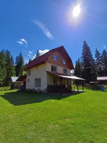 Ein Haus auf einem Feld mit der Sonne am Himmel in der Unterkunft Cabana Elena in Izlaz