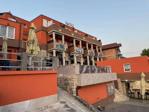 a hotel with an orange building in front of it at Hotel Nur in Mostar