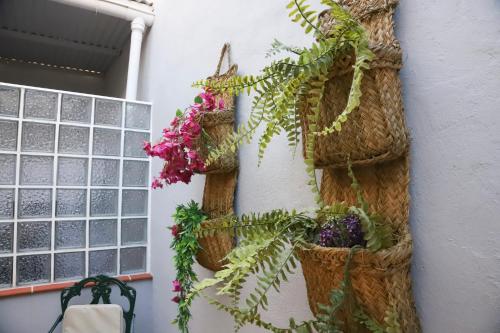 a wall with baskets and flowers on it at Hostal Cuevas in Fuengirola