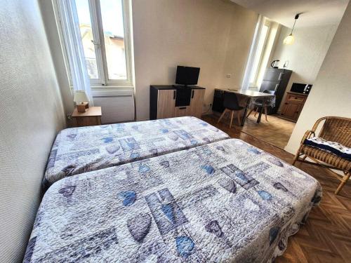 - une chambre avec deux lits et une chambre avec une table dans l'établissement Résidence Le Juturna - Studio à proximité du centre ville et des Thermes d'Aix-les-Bains ! MAE-7054, à Aix-les-Bains