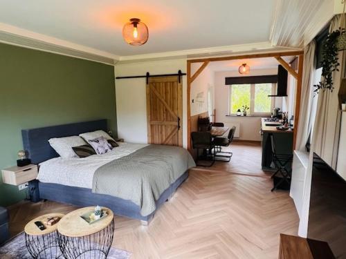 a bedroom with a bed and a desk and a table at Kip en Hei in Schijf