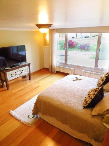 エル・ボルソンにあるLa Aguadaの大きなベッドと大きな窓のある寝室