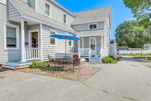 a table with a blue umbrella in front of a house at Walk to Pier and Ocean Apt in Old Orchard Beach! in Old Orchard Beach