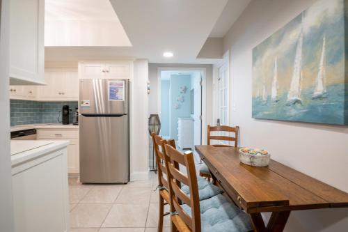 a kitchen with a wooden table and a refrigerator at Completely Remodeled - Beach Access 3 Doors Down - Near Kure Beach Pier in Kure Beach