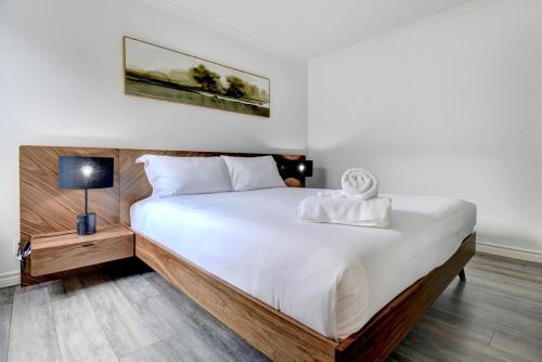ein Schlafzimmer mit einem großen Bett mit weißer Bettwäsche in der Unterkunft Cozy 1 Bedroom Domaine de la Montagne Tremblant in Mont-Tremblant