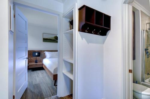ein Schlafzimmer mit einem Bett und ein Badezimmer mit einem Schrank in der Unterkunft Cozy 1 Bedroom Domaine de la Montagne Tremblant in Mont-Tremblant