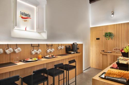a kitchen with a counter and stools in a restaurant at Fortunella Suites Luxury in Portici