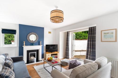 a living room with a couch and a fireplace at Peaceful - 10-min walk to beach - The White House in Falmouth