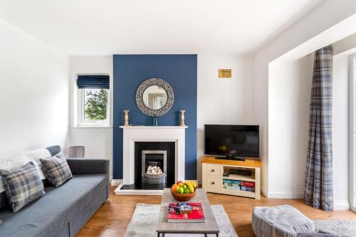a living room with a gray couch and a fireplace at Peaceful - 10-min walk to beach - The White House in Falmouth
