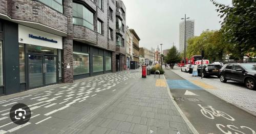 an empty city street with cars parked in front of buildings at The XL modern retreat in London