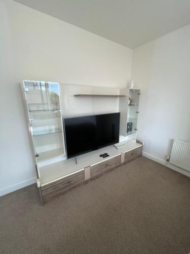 a living room with a flat screen tv on a entertainment center at The XL modern retreat in London
