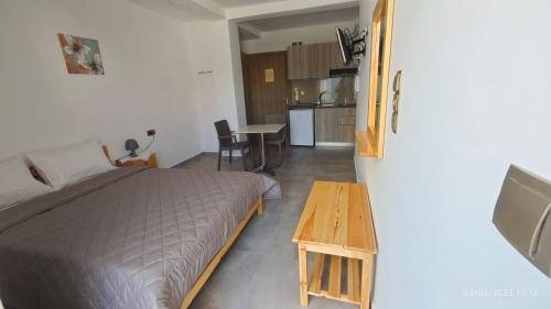 a bedroom with a bed and a table and a kitchen at ΣΤΕΡΓΙΟΥ ΠΑΝΑΓΙΩΤΗΣ studio in Loutra Edipsou