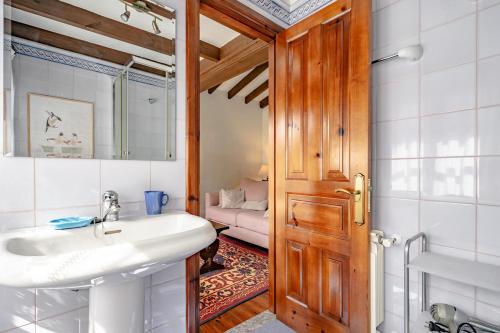 ein Badezimmer mit Waschbecken und Spiegel in der Unterkunft La Casina del rincón in Mestas de Con