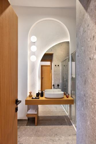 a bathroom with a sink and a large mirror at Fortunella Suites Luxury in Portici