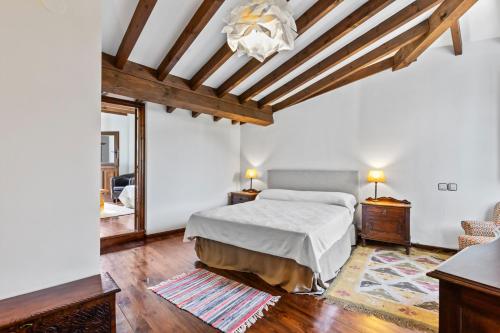 Schlafzimmer mit einem Bett und einer Balkendecke in der Unterkunft La Casina del rincón in Mestas de Con