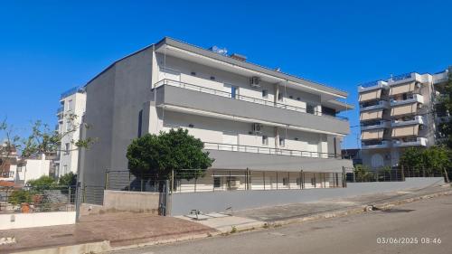 a tall white building on the side of a street at ΣΤΕΡΓΙΟΥ ΠΑΝΑΓΙΩΤΗΣ studio in Loutra Edipsou