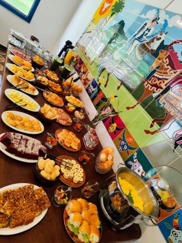 una mesa con un montón de diferentes tipos de comida en Pouso do parente, en Pirenópolis