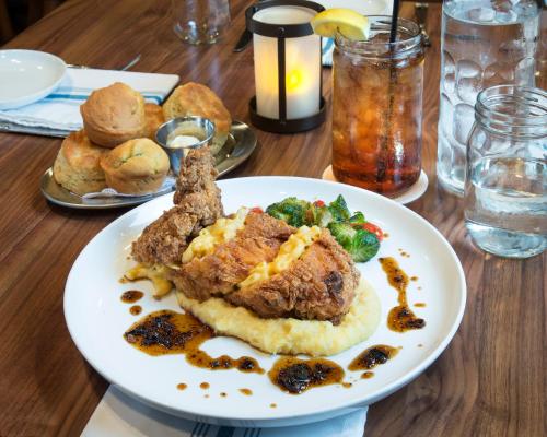 a white plate of food on a wooden table at The Whitehall Houston in Houston
