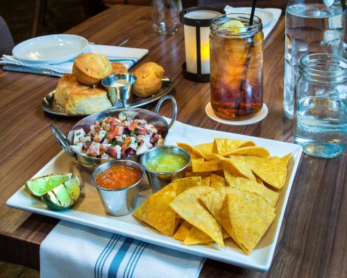 a table with a plate of food with chips and salsa at The Whitehall Houston in Houston