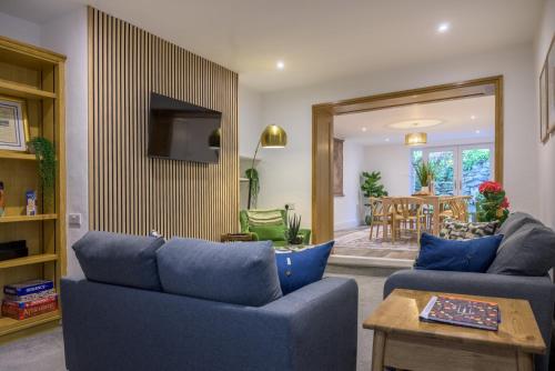 a living room with two blue couches and a table at Moss Crag in Penrith