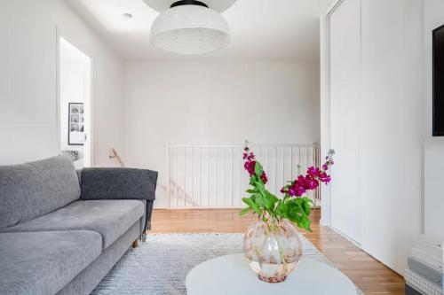 a living room with a couch and a vase with flowers at Appartment close to Hyllie in Klagshamn