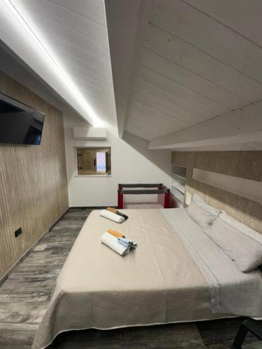 a bedroom with a large bed with two towels on it at Soulmondo Beach Rooms in Campomarino