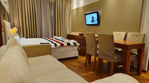 a hotel room with a bed and a table and chairs at Dreamland Oasis 1 Studio in Chakvi