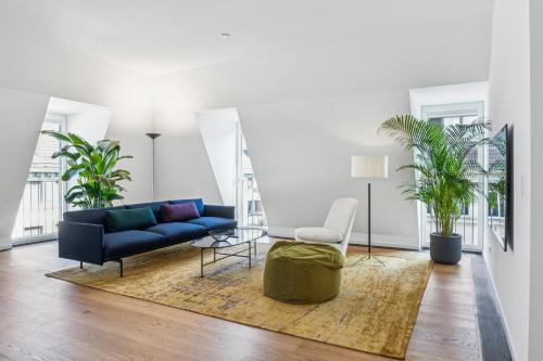 a living room with a blue couch and a chair at Horizon Home Löwenstrasse Penthouse in Zürich